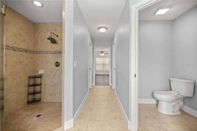 full bath with baseboards, tile patterned flooring, toilet, tiled shower, and ceiling fan
