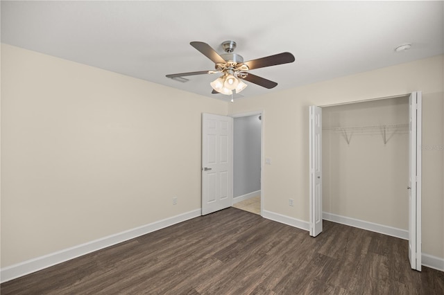 unfurnished bedroom featuring wood finished floors, a closet, a ceiling fan, and baseboards