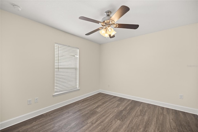 unfurnished room featuring baseboards, a ceiling fan, and dark wood finished floors