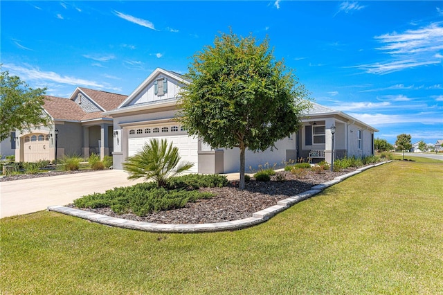view of front of property with a garage, stucco siding, a front yard, and concrete driveway