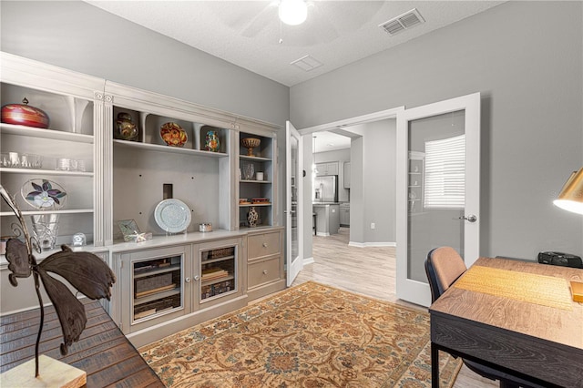 home office with ceiling fan, baseboards, wood finished floors, and visible vents