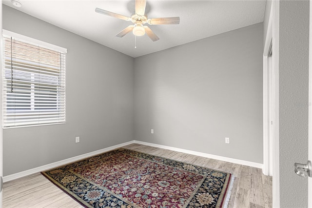 spare room with light wood-style flooring, baseboards, and ceiling fan