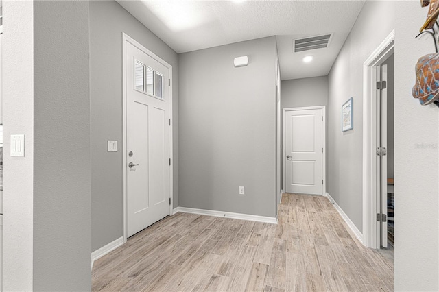 entryway featuring light wood-type flooring, visible vents, and baseboards