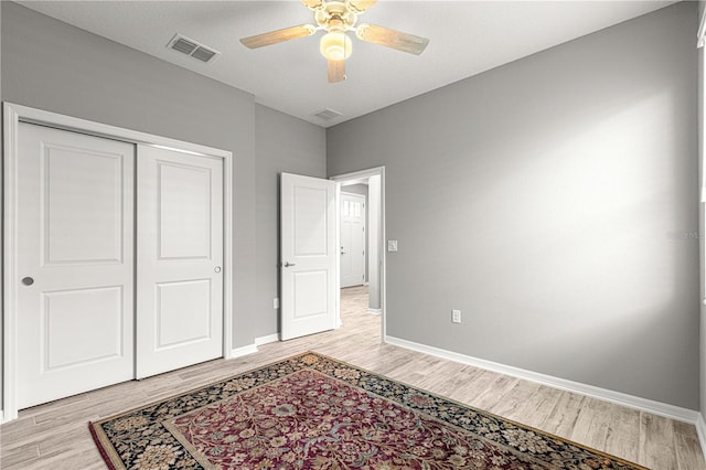 unfurnished bedroom with visible vents, light wood finished floors, and baseboards