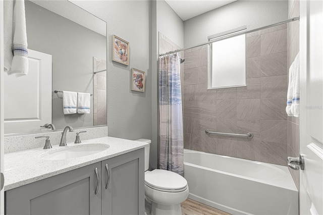 bathroom with toilet, wood finished floors, shower / tub combo with curtain, a textured wall, and vanity