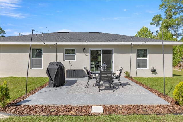77 Locust Dr, Ocala, FL 34472 - rear view of house with stucco siding, a patio, and a lawn
