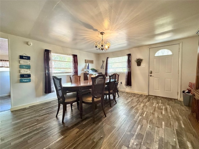 dining area featuring dark wood-style floors, baseboards, an inviting chandelier, and a healthy amount of sunlight
