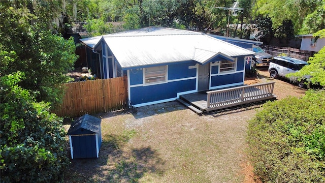 bungalow featuring metal roof and fence