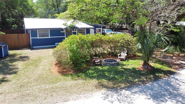 view of yard with an outdoor fire pit and fence