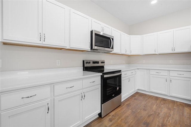kitchen featuring appliances with stainless steel finishes, light countertops, dark wood-style floors, white cabinetry, and recessed lighting