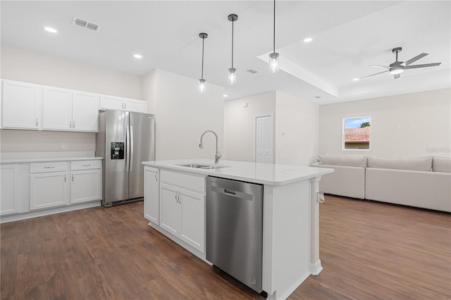 kitchen featuring a sink, stainless steel appliances, open floor plan, dark wood finished floors, and light countertops