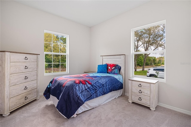 bedroom with light colored carpet and baseboards