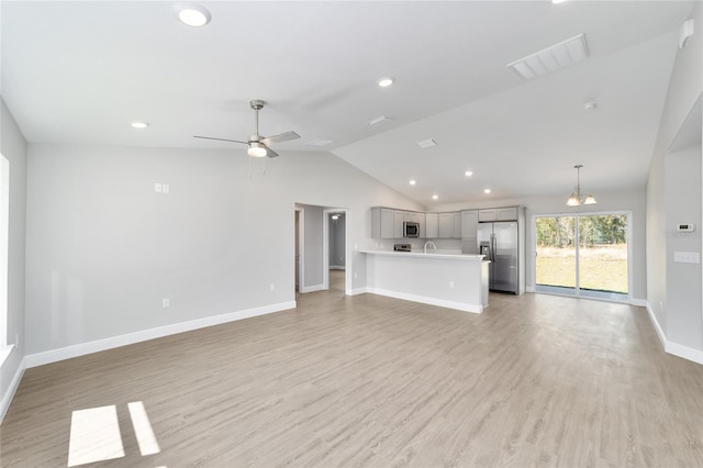 10374 SE 126th Ln, Belleview, FL 34420 - unfurnished living room featuring a ceiling fan, visible vents, vaulted ceiling, baseboards, and light wood-style floors