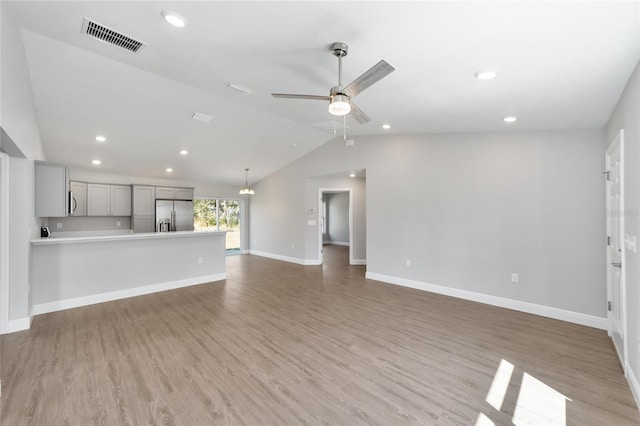 10374 SE 126th Ln, Belleview, FL 34420 - unfurnished living room with ceiling fan, vaulted ceiling, light wood finished floors, and visible vents
