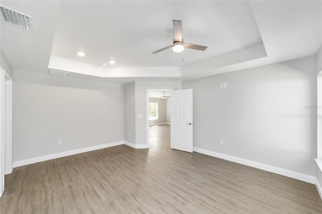 10374 SE 126th Ln, Belleview, FL 34420 - spare room featuring visible vents, ceiling fan, wood finished floors, and a tray ceiling