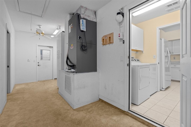 interior space featuring cabinet space, visible vents, washer and dryer, attic access, and light colored carpet