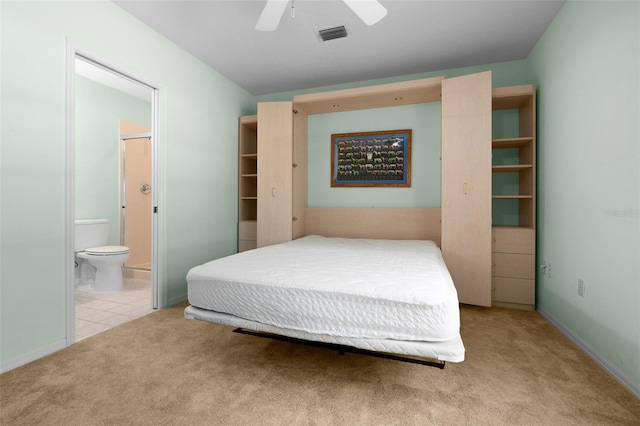 carpeted bedroom featuring baseboards, visible vents, connected bathroom, and ceiling fan