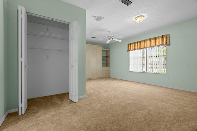 unfurnished bedroom with baseboards, visible vents, a closet, and light colored carpet