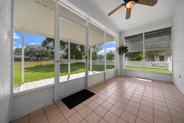 unfurnished sunroom with a wealth of natural light and a ceiling fan