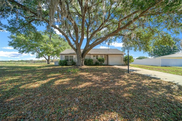 view of front facade featuring concrete driveway, a front yard, fence, and a garage