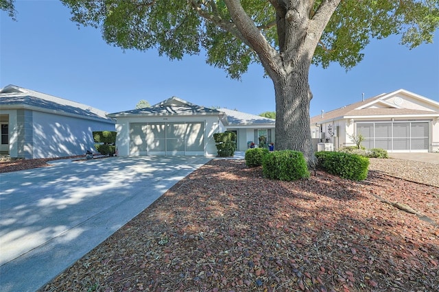 ranch-style home featuring concrete driveway, stucco siding, and a garage