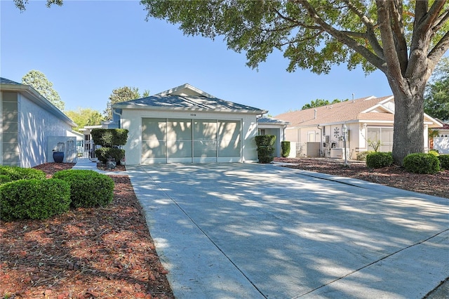 bungalow-style home featuring a garage, driveway, and stucco siding