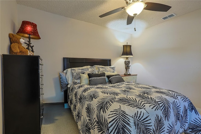 carpeted bedroom with visible vents, baseboards, a ceiling fan, and a textured ceiling
