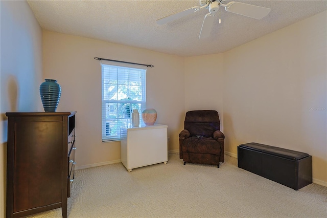 sitting room featuring baseboards, a ceiling fan, and carpet floors