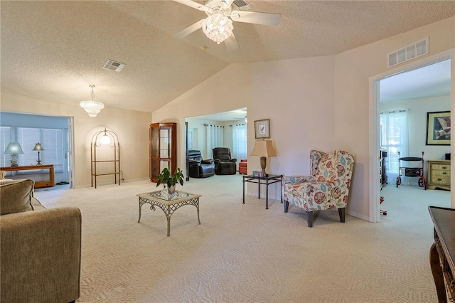 carpeted living area with visible vents, a textured ceiling, baseboards, and lofted ceiling