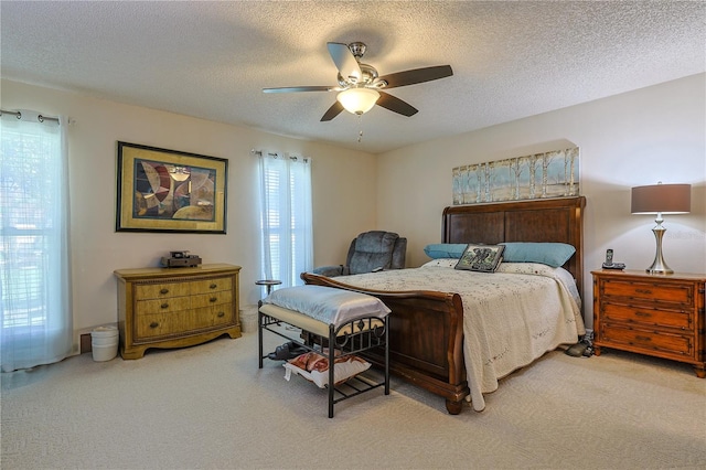 carpeted bedroom with a textured ceiling and a ceiling fan