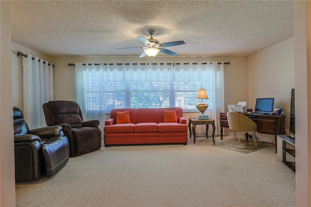 living area with ceiling fan, carpet floors, a textured ceiling, and a healthy amount of sunlight