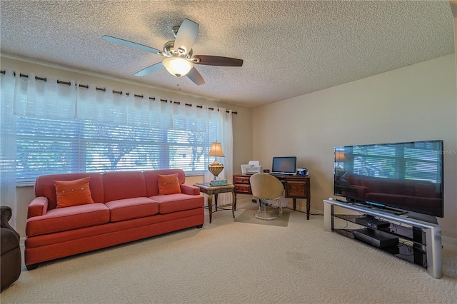 living room featuring a ceiling fan, carpet flooring, and a textured ceiling