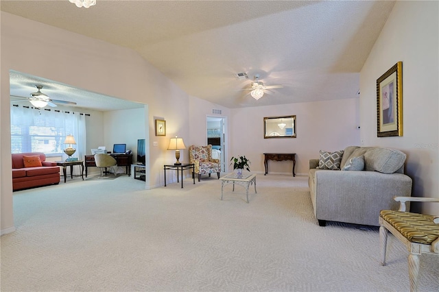 carpeted living area featuring baseboards, visible vents, vaulted ceiling, and a ceiling fan