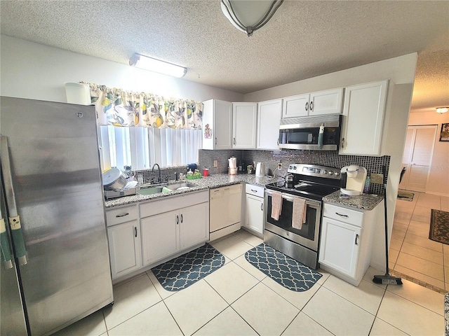 5606 SW 107th St, Ocala, FL 34476 - kitchen featuring tasteful backsplash, white cabinets, a sink, and stainless steel appliances