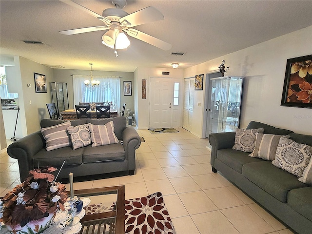5606 SW 107th St, Ocala, FL 34476 - living room with ceiling fan with notable chandelier, light tile patterned floors, visible vents, and plenty of natural light
