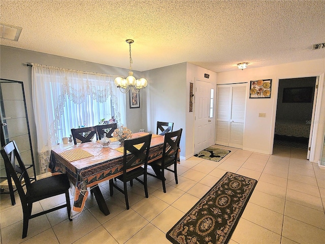 5606 SW 107th St, Ocala, FL 34476 - dining area featuring baseboards, an inviting chandelier, a textured ceiling, light tile patterned flooring, and visible vents