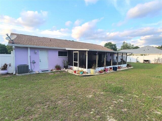 5606 SW 107th St, Ocala, FL 34476 - rear view of house with a sunroom, a yard, stucco siding, fence private yard, and central AC unit
