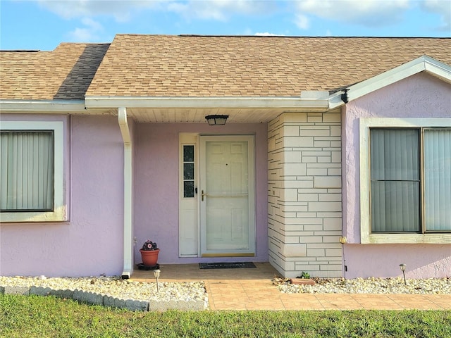 5606 SW 107th St, Ocala, FL 34476 - view of exterior entry with stucco siding and a shingled roof