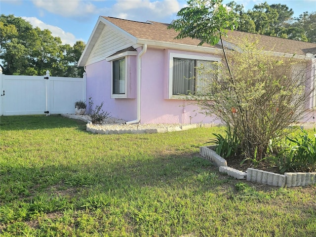 5606 SW 107th St, Ocala, FL 34476 - view of home's exterior with fence, a shingled roof, a lawn, and stucco siding