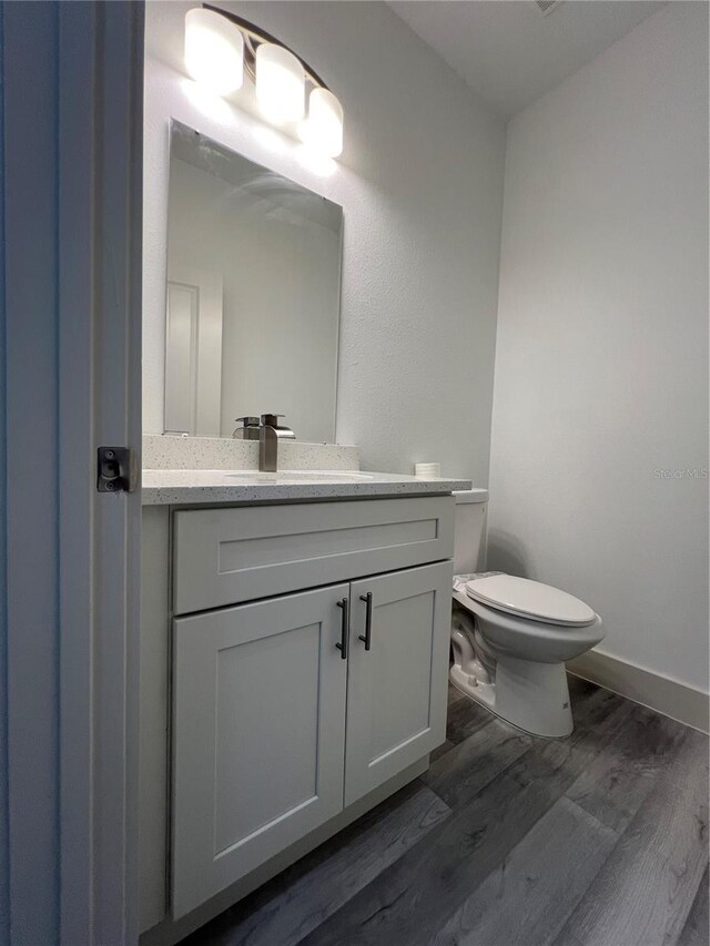 1581 W Saint Elizabeth Pl, Citrus Springs, FL 34434 - bathroom with toilet, vanity, wood finished floors, and baseboards