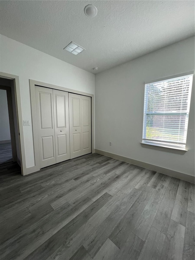 1581 W Saint Elizabeth Pl, Citrus Springs, FL 34434 - unfurnished bedroom featuring a textured ceiling, wood finished floors, baseboards, and a closet