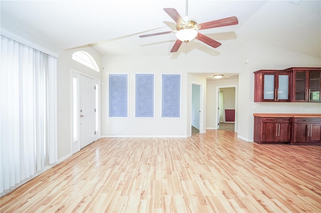 unfurnished living room featuring lofted ceiling, light wood-style floors, ceiling fan, and baseboards