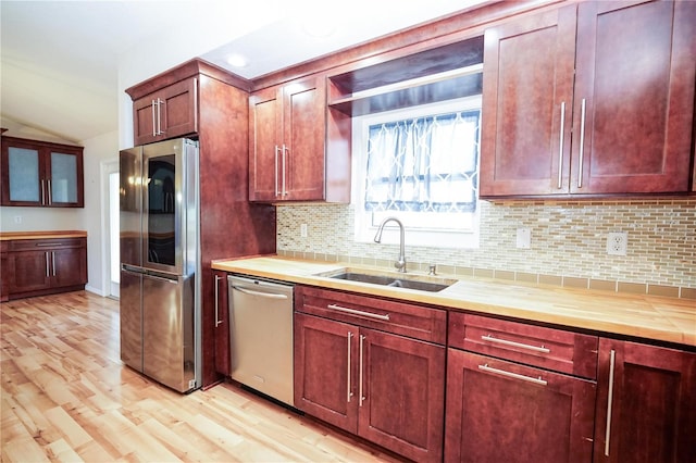 kitchen featuring decorative backsplash, stainless steel appliances, light countertops, and a sink