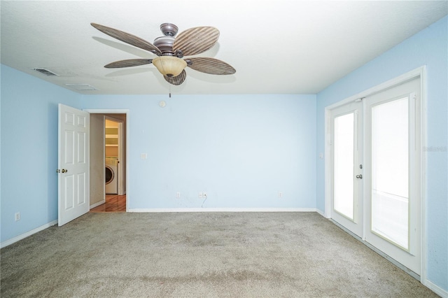 empty room with washer / dryer, ceiling fan, carpet flooring, baseboards, and visible vents