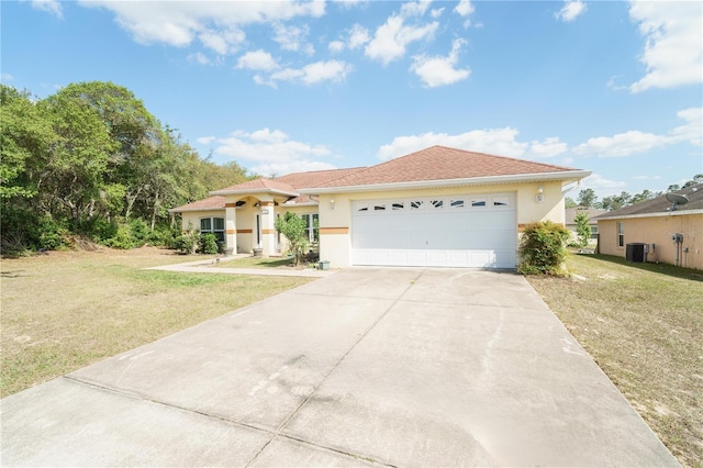 view of front of home featuring stucco siding, central air condition unit, a garage, driveway, and a front lawn