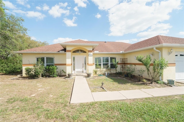 single story home featuring a front yard, a garage, and stucco siding
