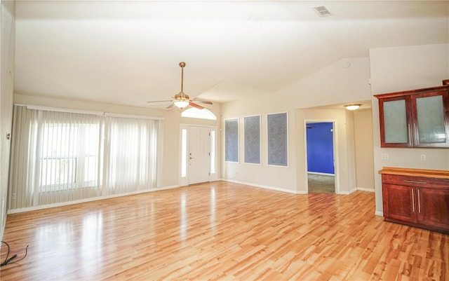 unfurnished living room with visible vents, vaulted ceiling, baseboards, light wood-type flooring, and a ceiling fan