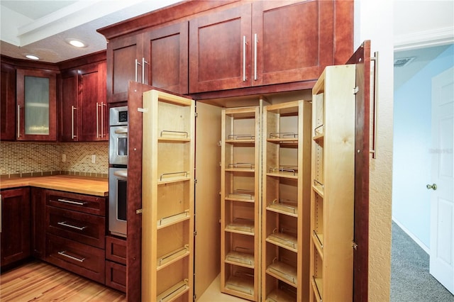kitchen with backsplash, recessed lighting, dark brown cabinets, and light countertops