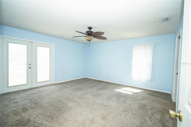carpeted empty room with visible vents, ceiling fan, french doors, and baseboards