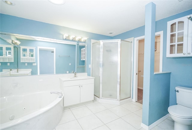 bathroom featuring a tub with jets, tile patterned flooring, a shower stall, toilet, and vanity